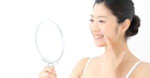 手鏡で口元を見る女性