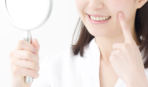 鏡で自分の歯を見る女性