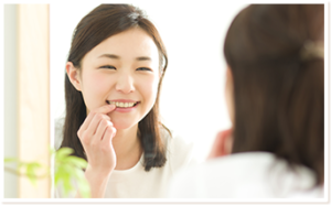 鏡で自分の歯を見る女性