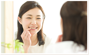 鏡で自分の歯を見る女性